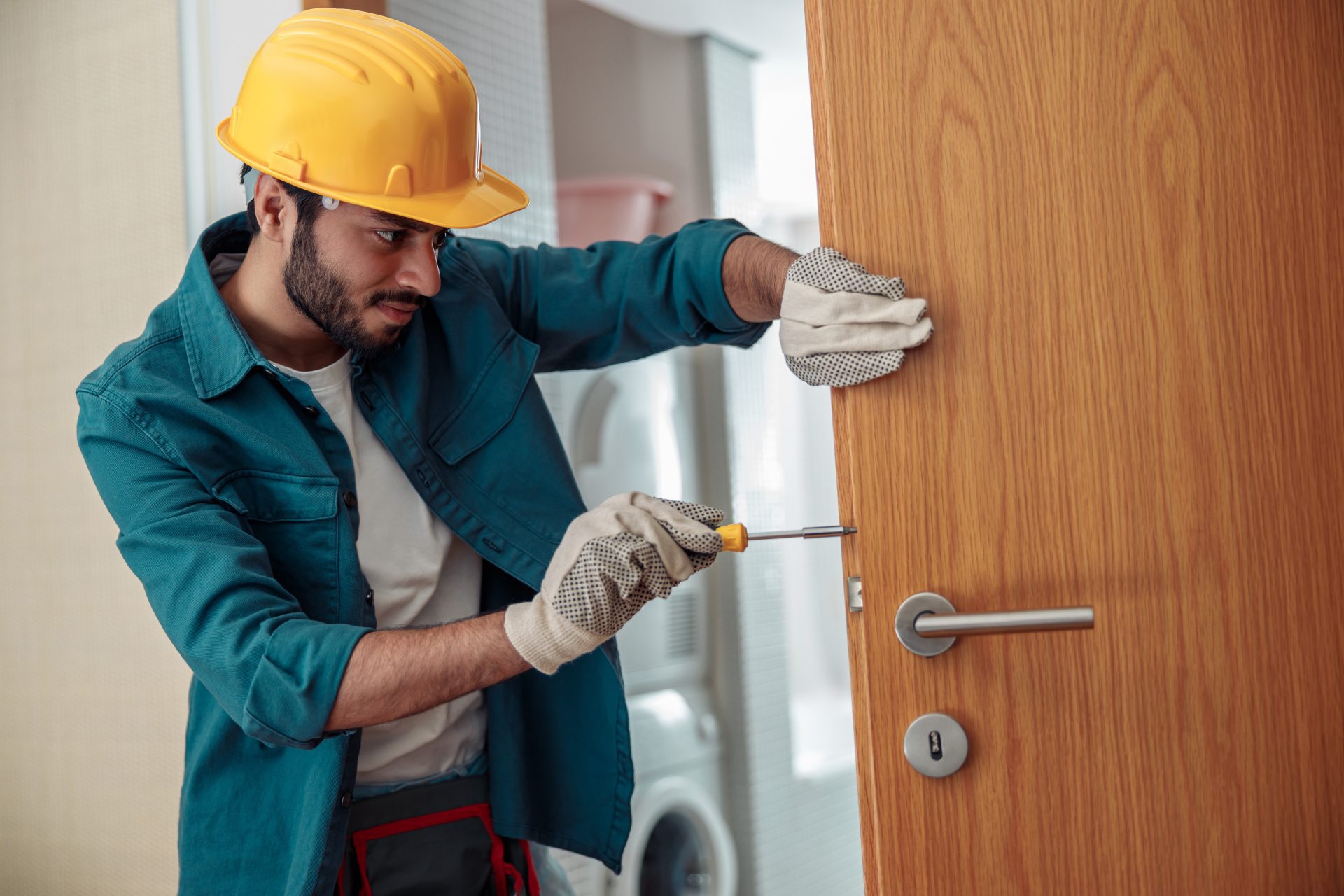 locksmith workman in uniform installing door knob 2023 01 05 00 20 11 utc - The LockSmith Co.